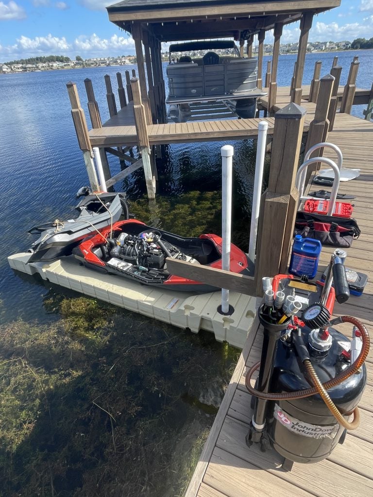 Makin Waves mechanic working on a personal watercraft at a residential dock